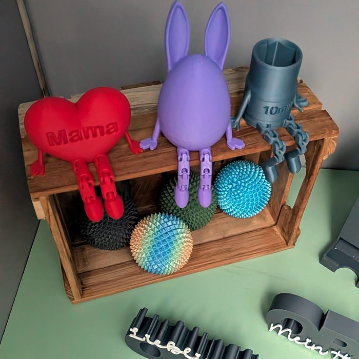 Hase, Herz mit Beinen und Holzkiste mit Figuren auf dem oberen Regal der Box