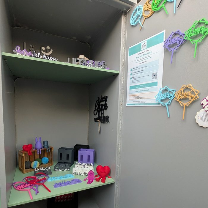 Geöffnete Box mit Regalböden voller bunter 3D-Druck-Produkte