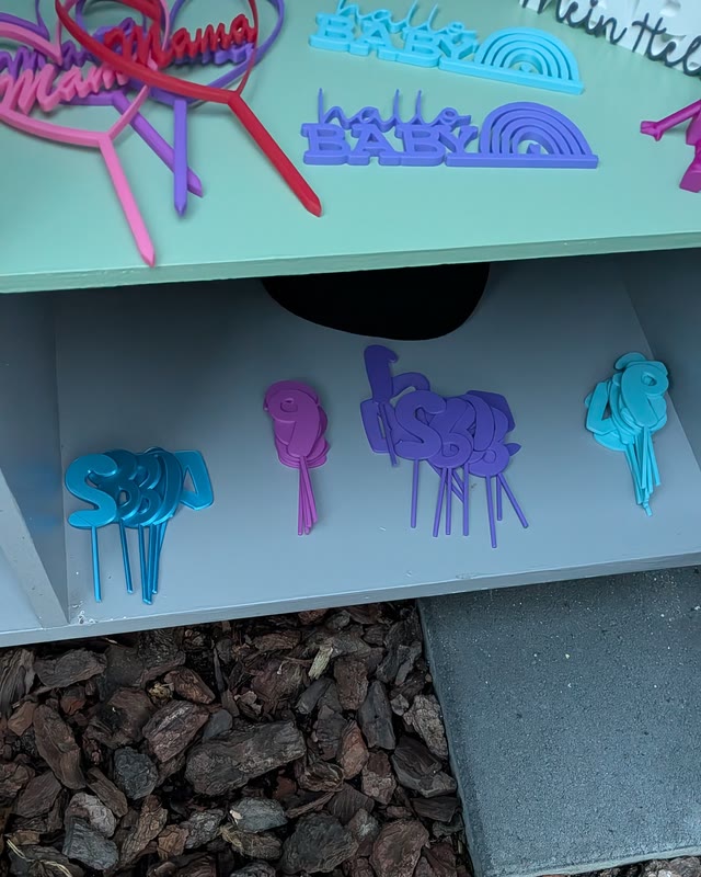 Bunte Stecker und Anhänger in Blau, Lila und Türkis auf dem Regalbrett